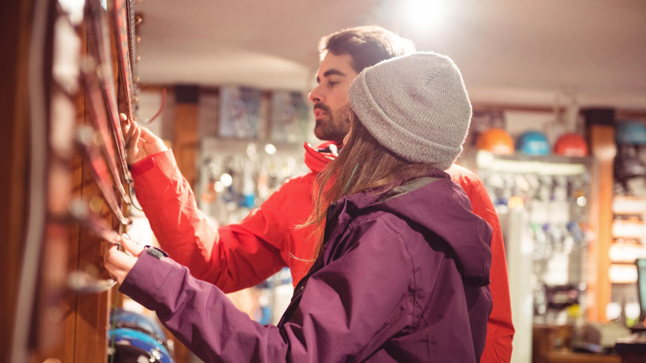 Deux personnes sont dans une boutique en train de choisir du matériel de ski - Investir proche des commodités