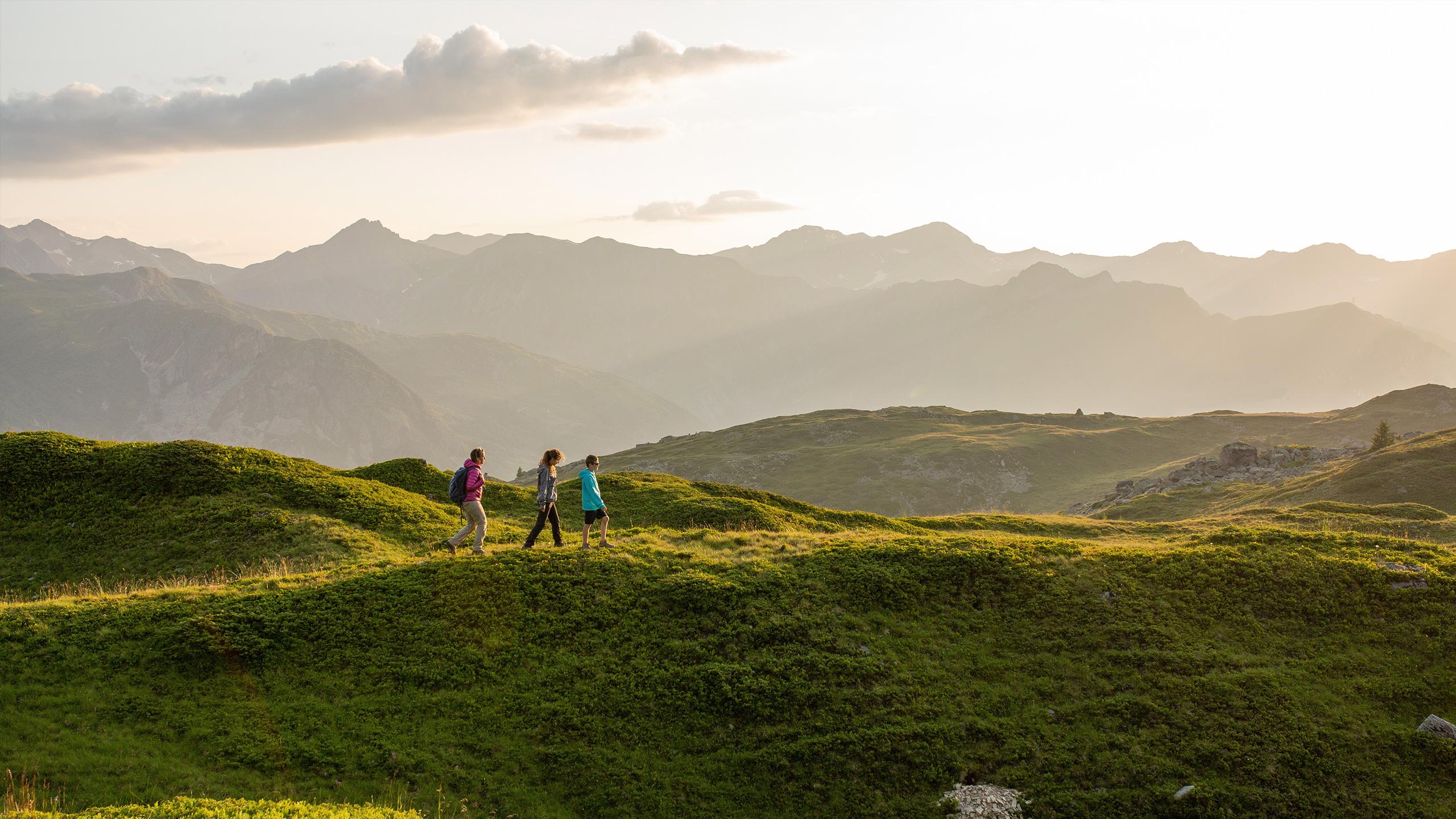 Des randonneurs marchent dans la montagne sur le domaine des 3 Vallées