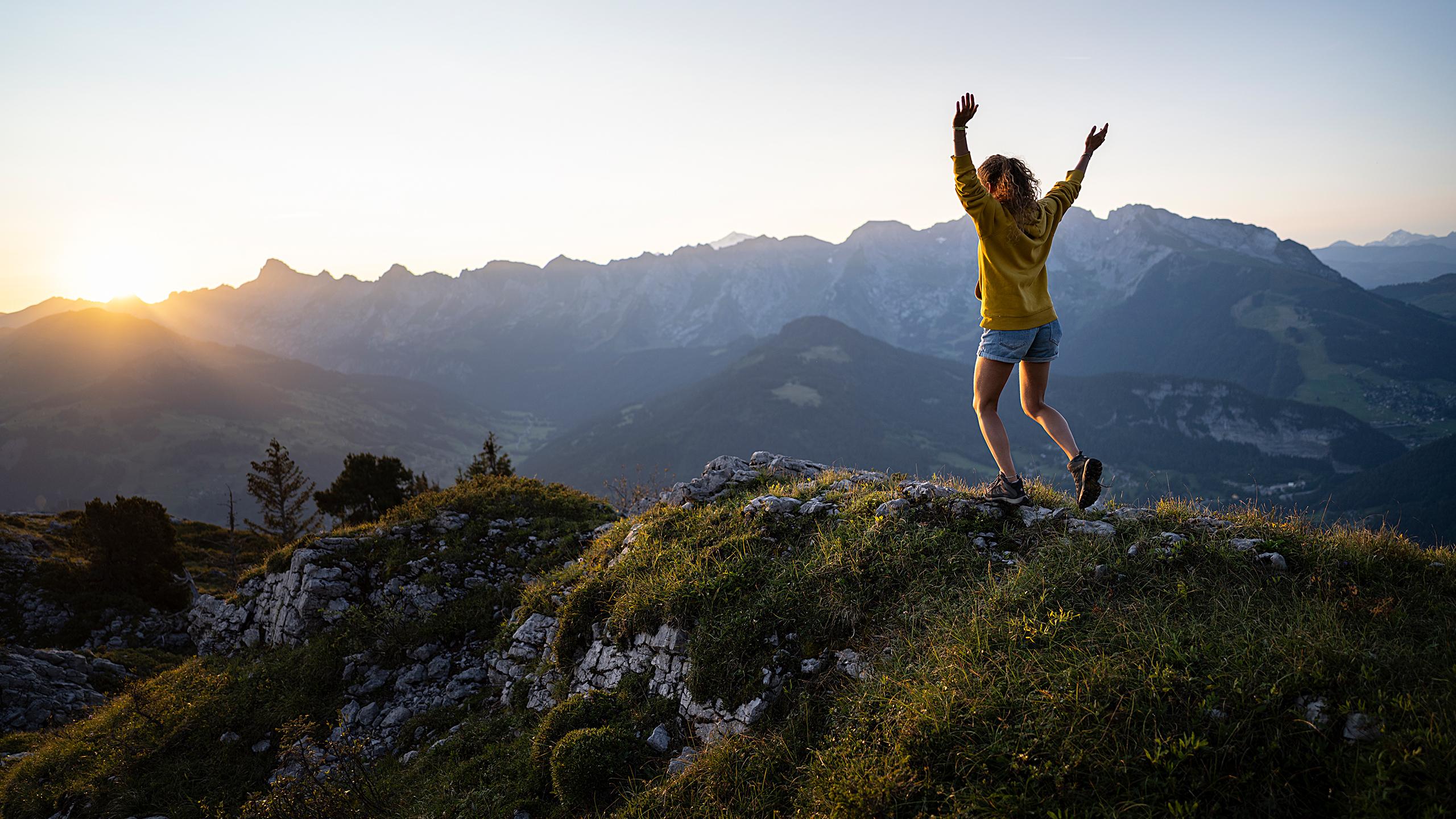 Femme sur le sommet d'une montage dans la chaîne des Aravis durant le coucher de soleil 