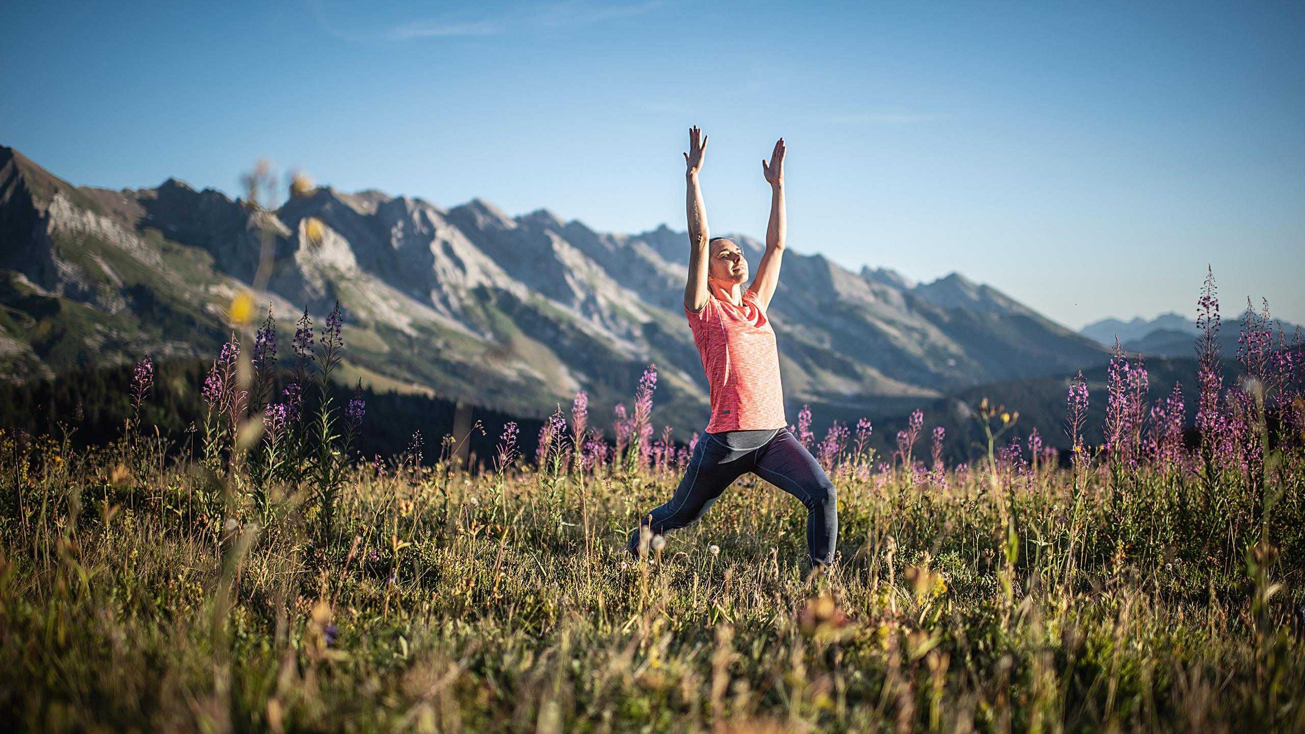 Femme entrain de faire du yoga dans un champ 