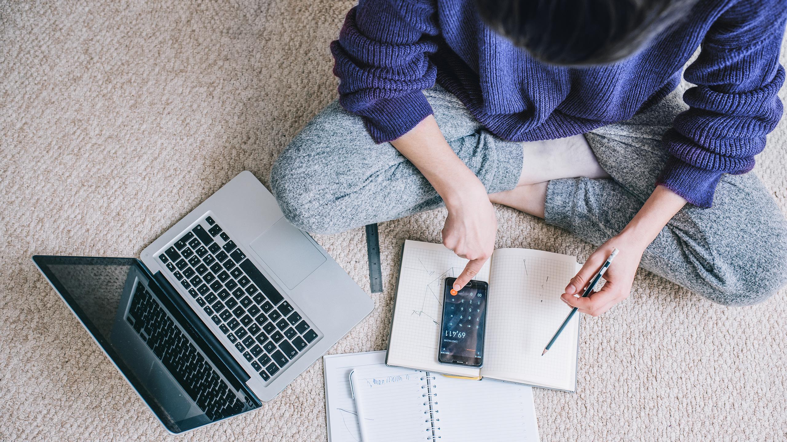 Une femme est en train d'effectuer un calcul sur sa s