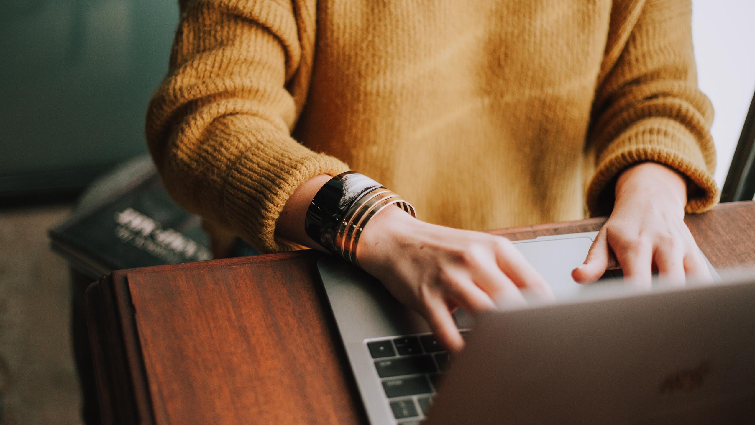 Une femme tape sur le clavier de son ordinateur portable