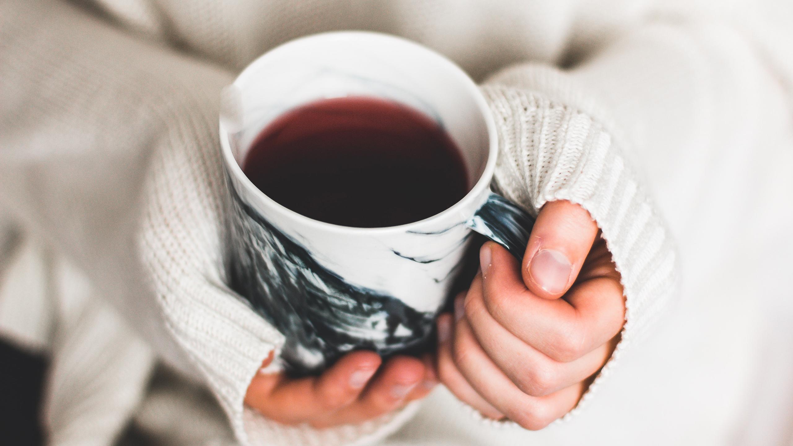 Une personne tient une tasse de café dans sa main