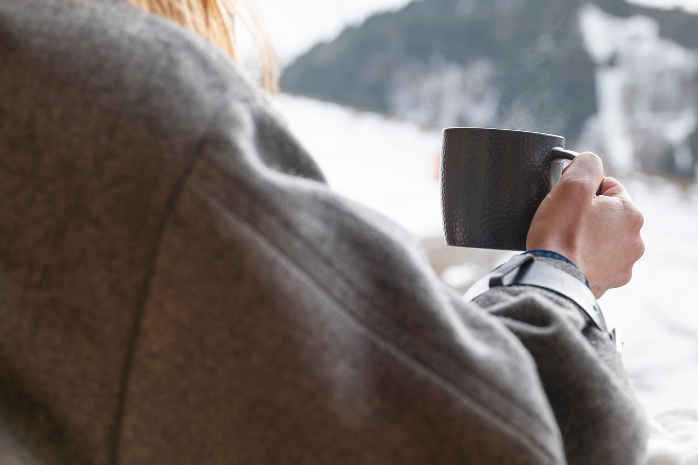 Femme prenant une photo sur un balcon de la résidence des Chalets Laska aux Contamines-Montjoie