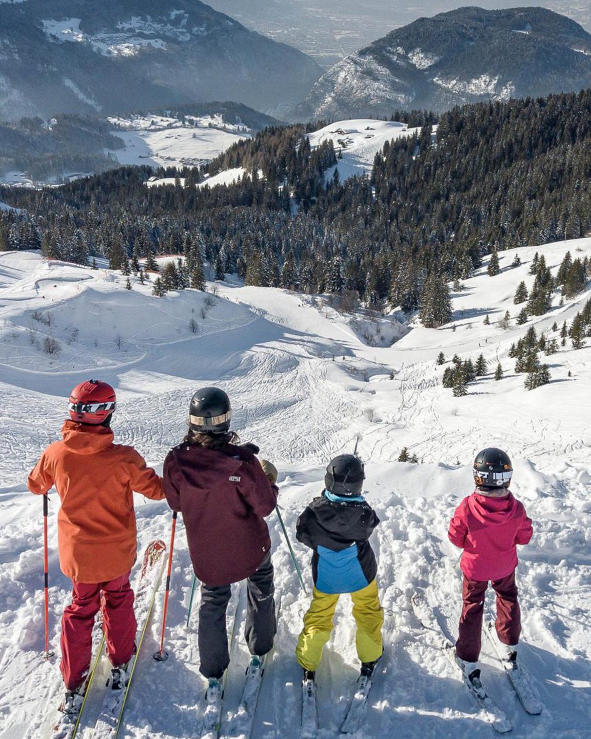 Une famille à skis observe le paysage depuis les pistes des Carroz
