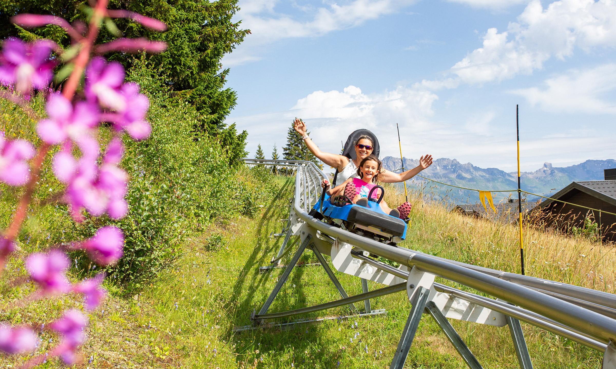 Une mère et sa fille font de la luge d'été aux Saisies, destination Espace Diamant en Savoie