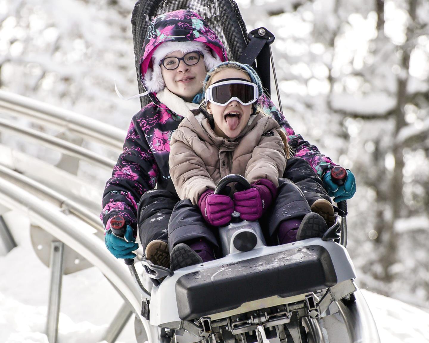 Des enfants font de la luge d'hiver aux Carroz 