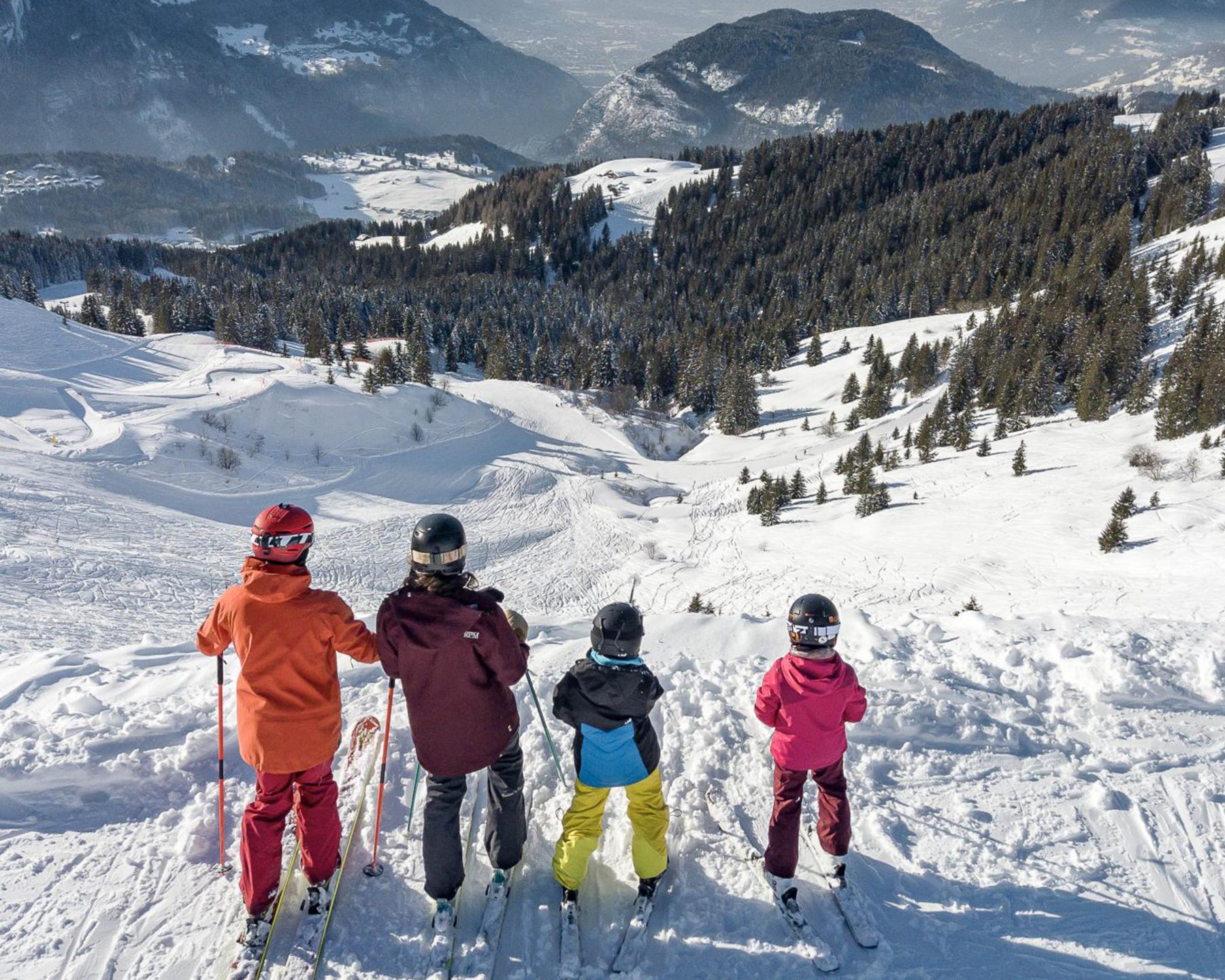 Une famille à skis observe le paysage depuis les pistes des Carroz