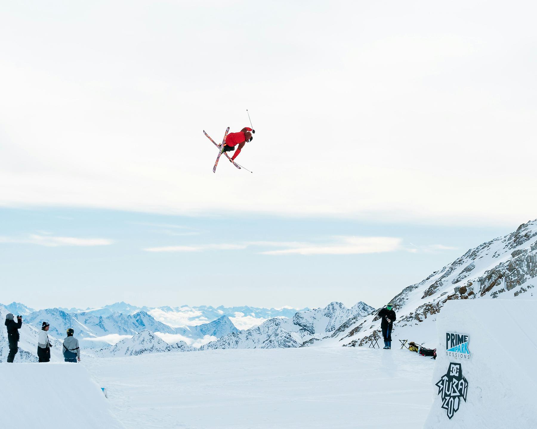 Un personne est en train de faire un saut en ski depuis le tremplin d'un snowpark