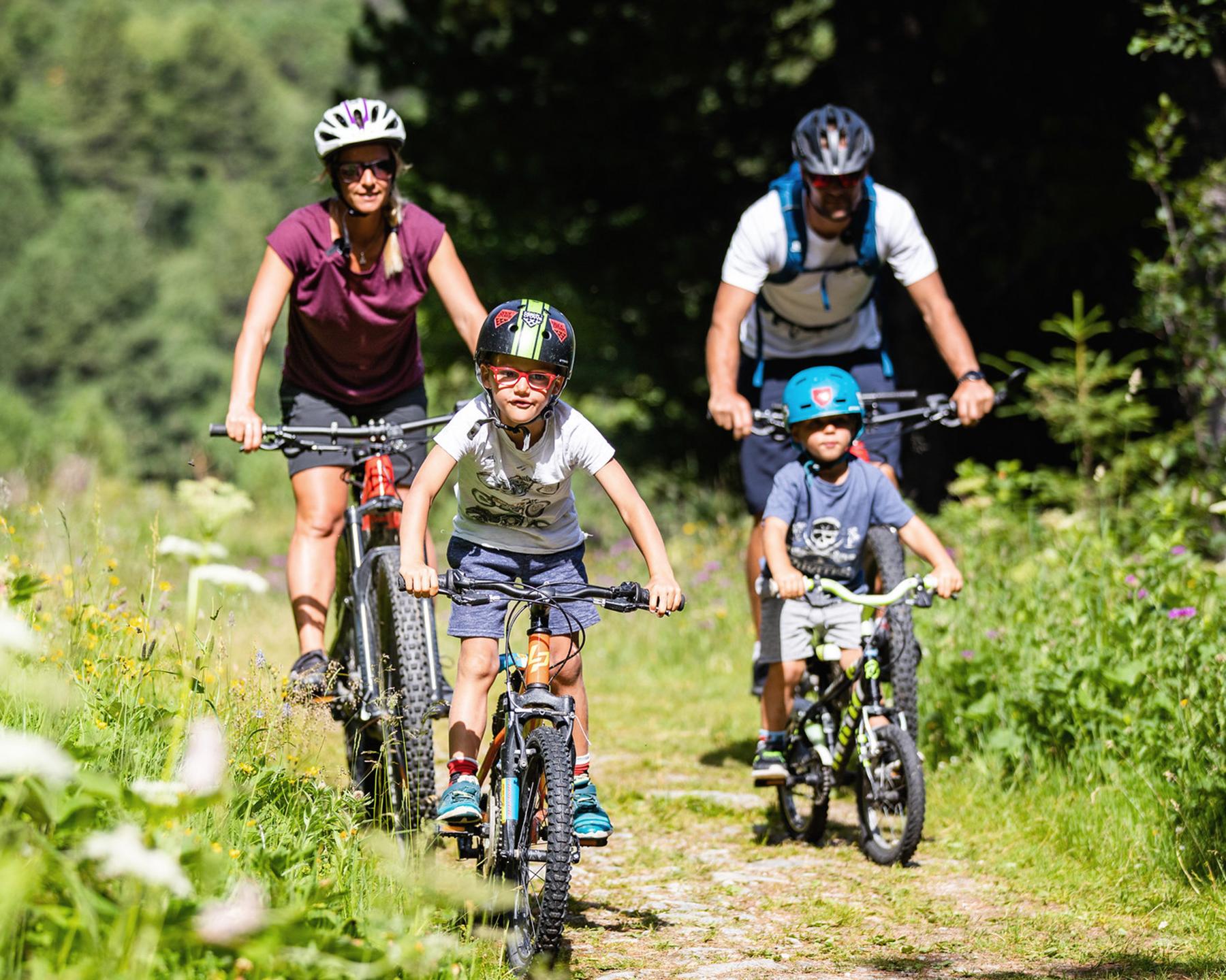 Une famille se balade à vélo dans la nature à Méribel